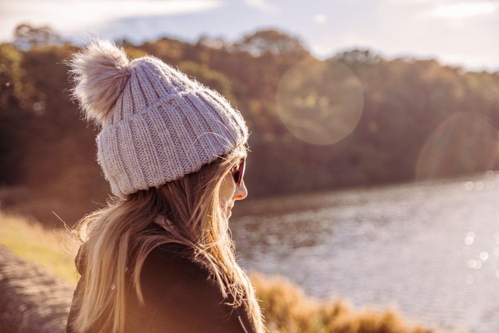 woman wearing jacket looking at body of water