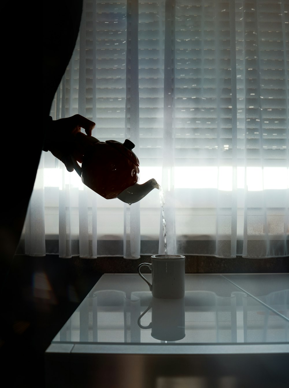 person pouring from teapot