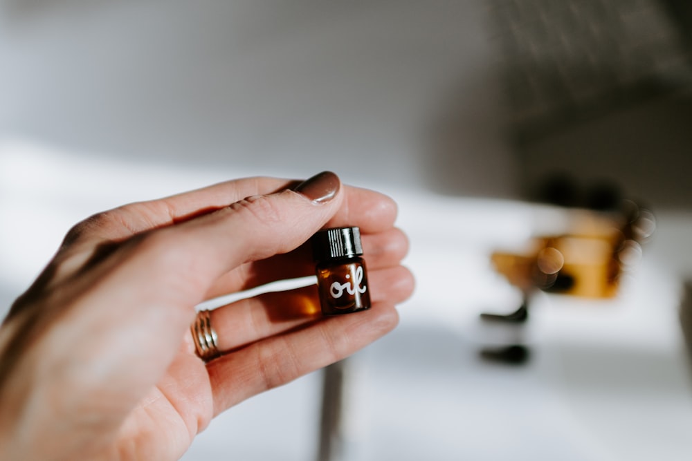 person holding brown glass bottle