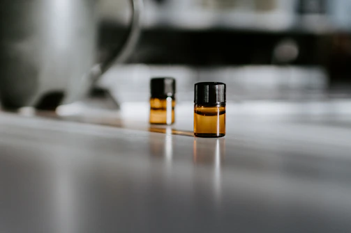 Close-up of amber glass vial with precise measuring scale under focused low key lighting.