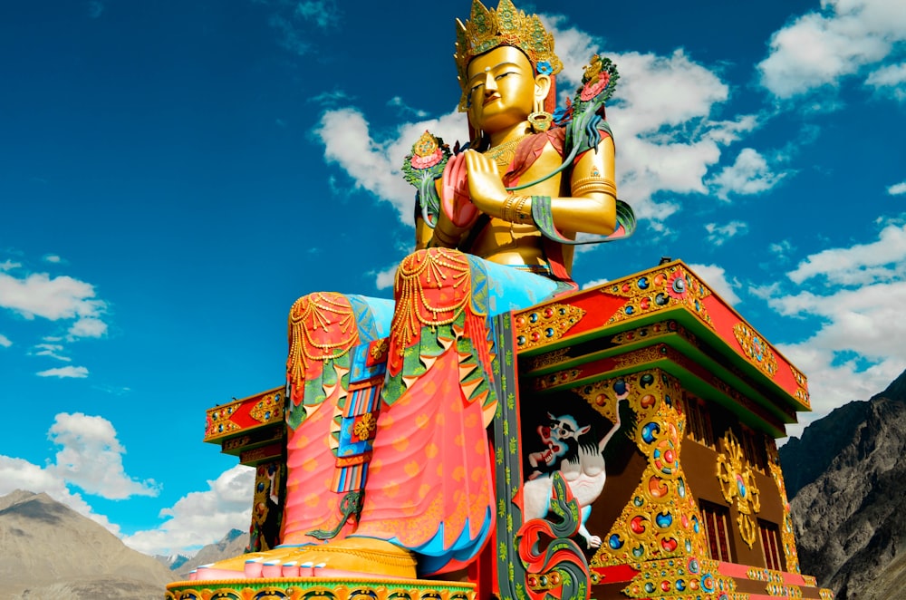 low angle photography of sitting Buddha statue under blue sky and white clouds at daytime