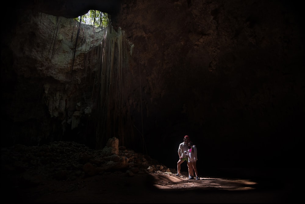 couple under cave during daytime