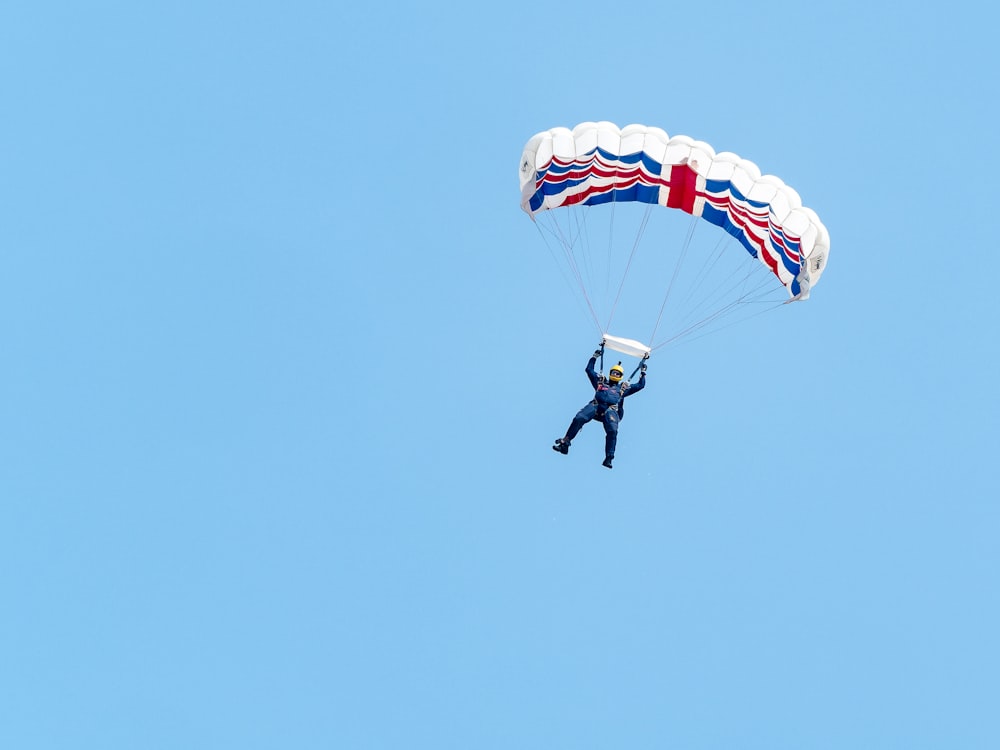 person paragliding under blue sky
