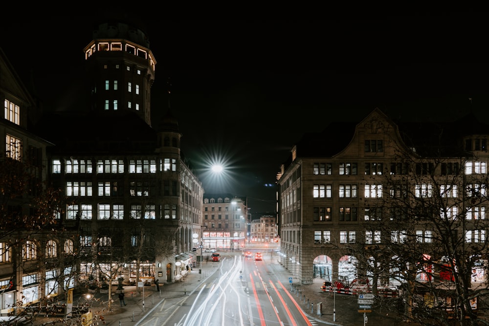 timelapse photography of cars passing between buildings at night