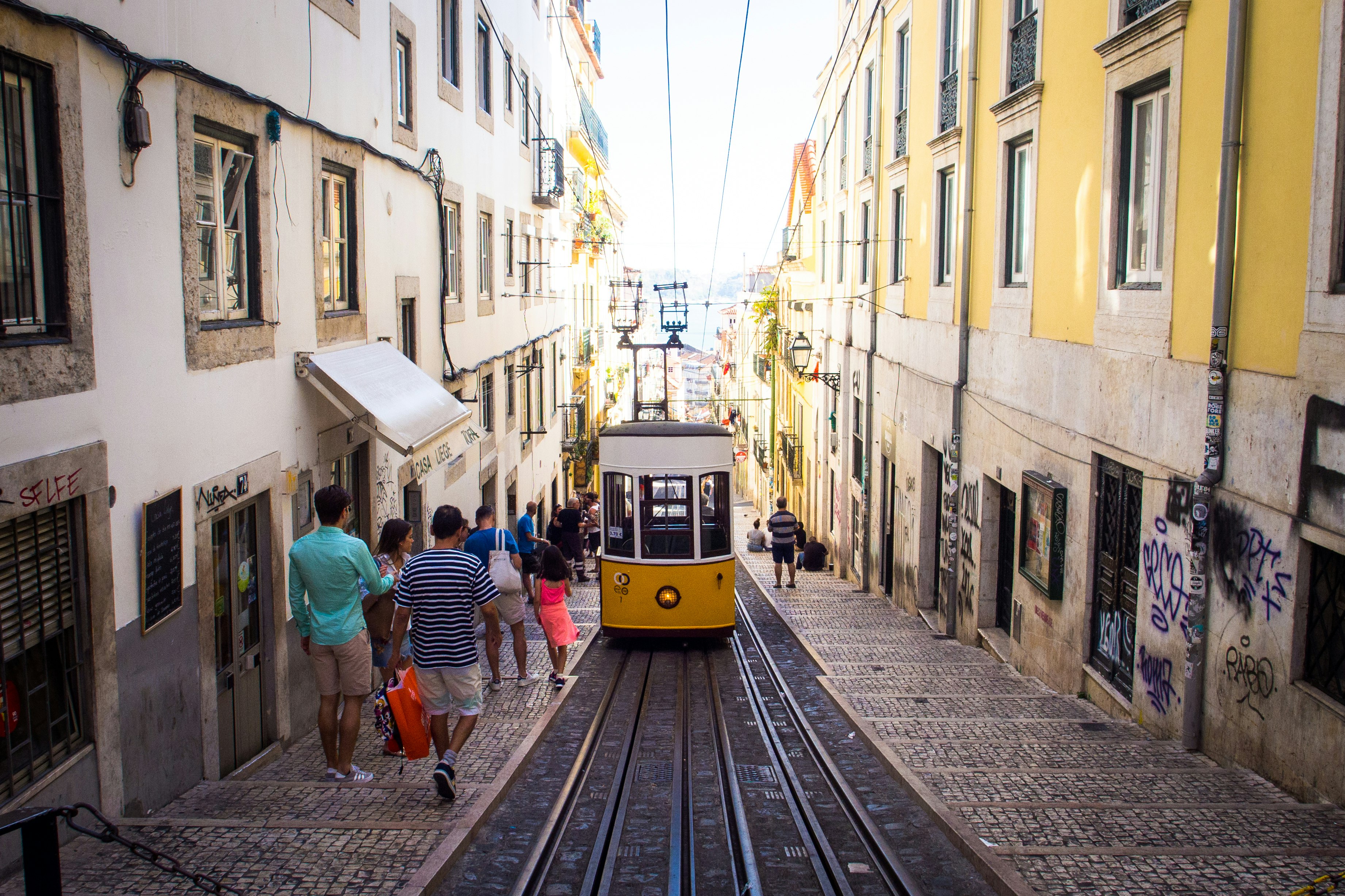 yellow and white pram train passing through streets