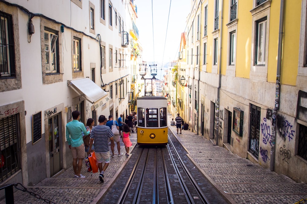 yellow and white pram train passing through streets