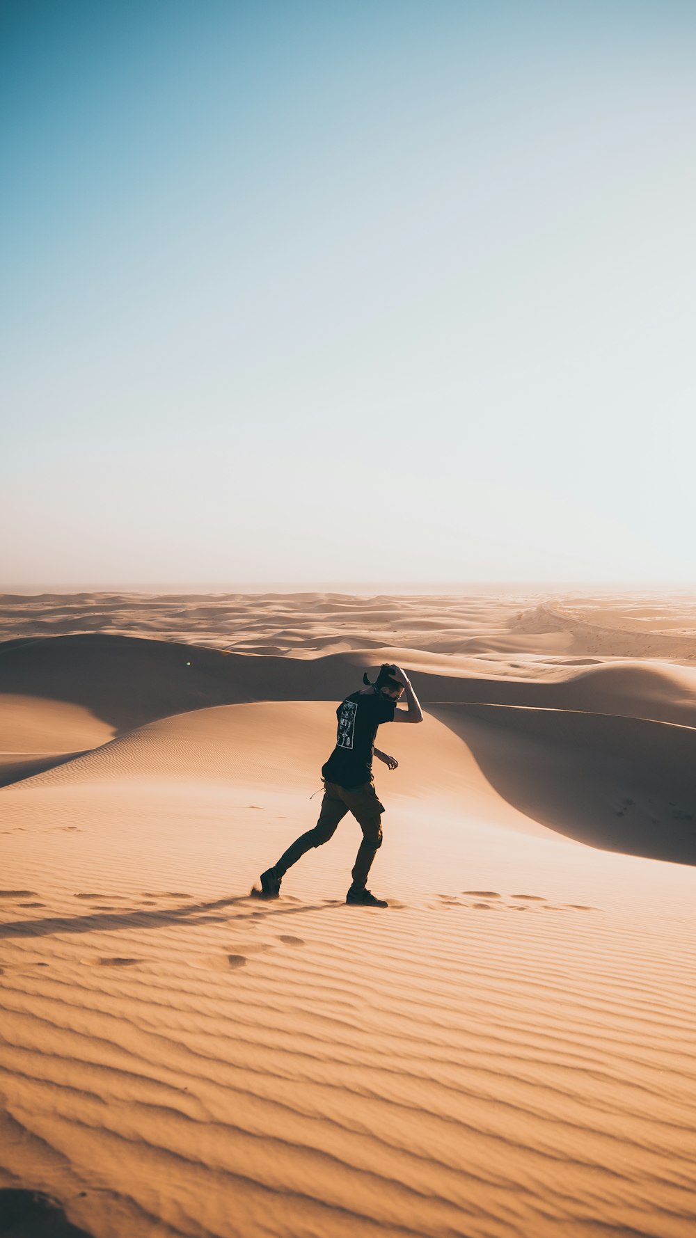 man playing on sand dunes