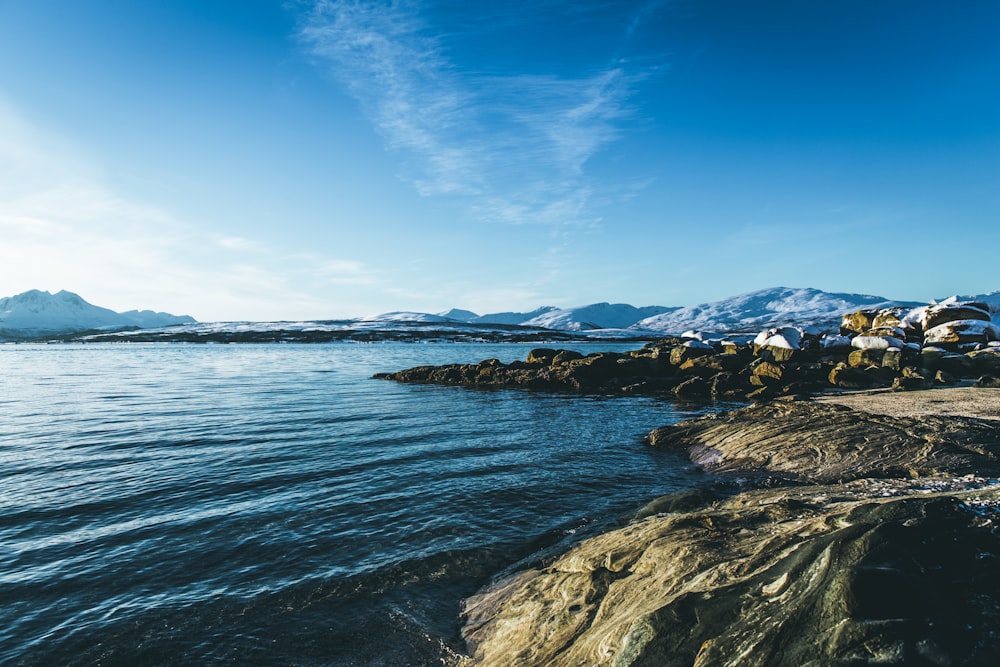 calm body of water under blue sky