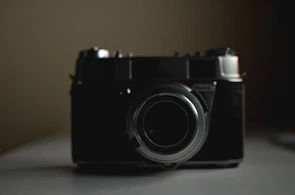 Minimalist artistic shot of a vintage film camera in soft light.