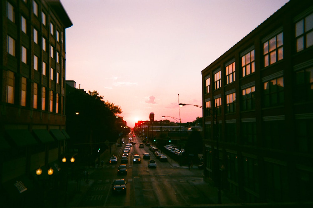 vehicles passing on road between buildings during daytime