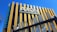 A modern building with a prominent sign that reads 'AXON Engineering & Building Company'. The structure features vertical yellow and white beams against a deep blue sky.
