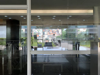 A sleek office entrance door with glass panels reflecting a busy cityscape.