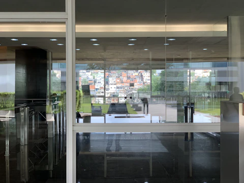 A sleek office entrance door with glass panels reflecting a busy cityscape.