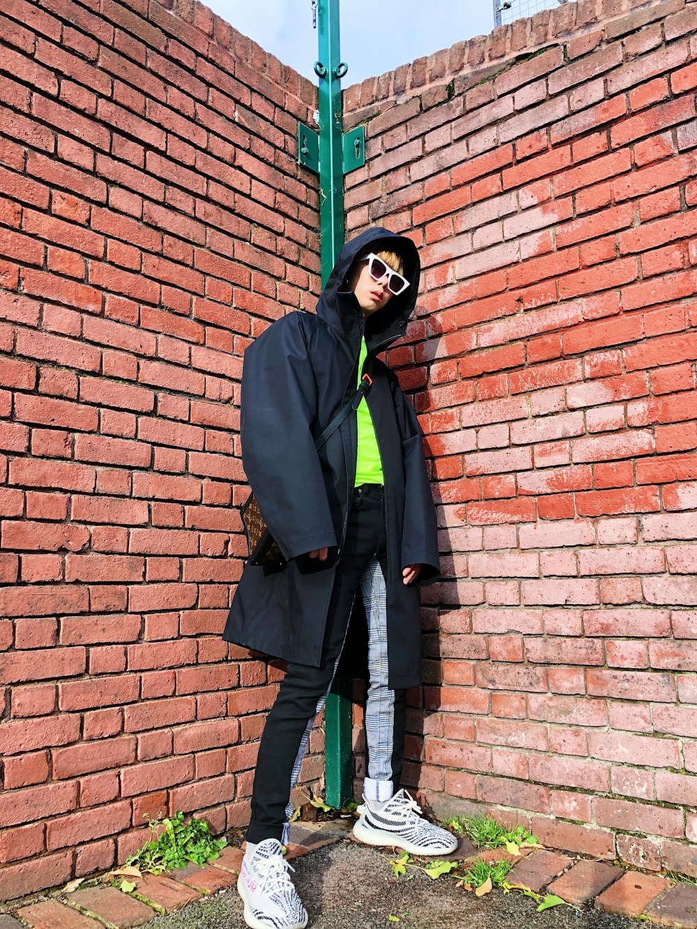 man standing behind bricks wall