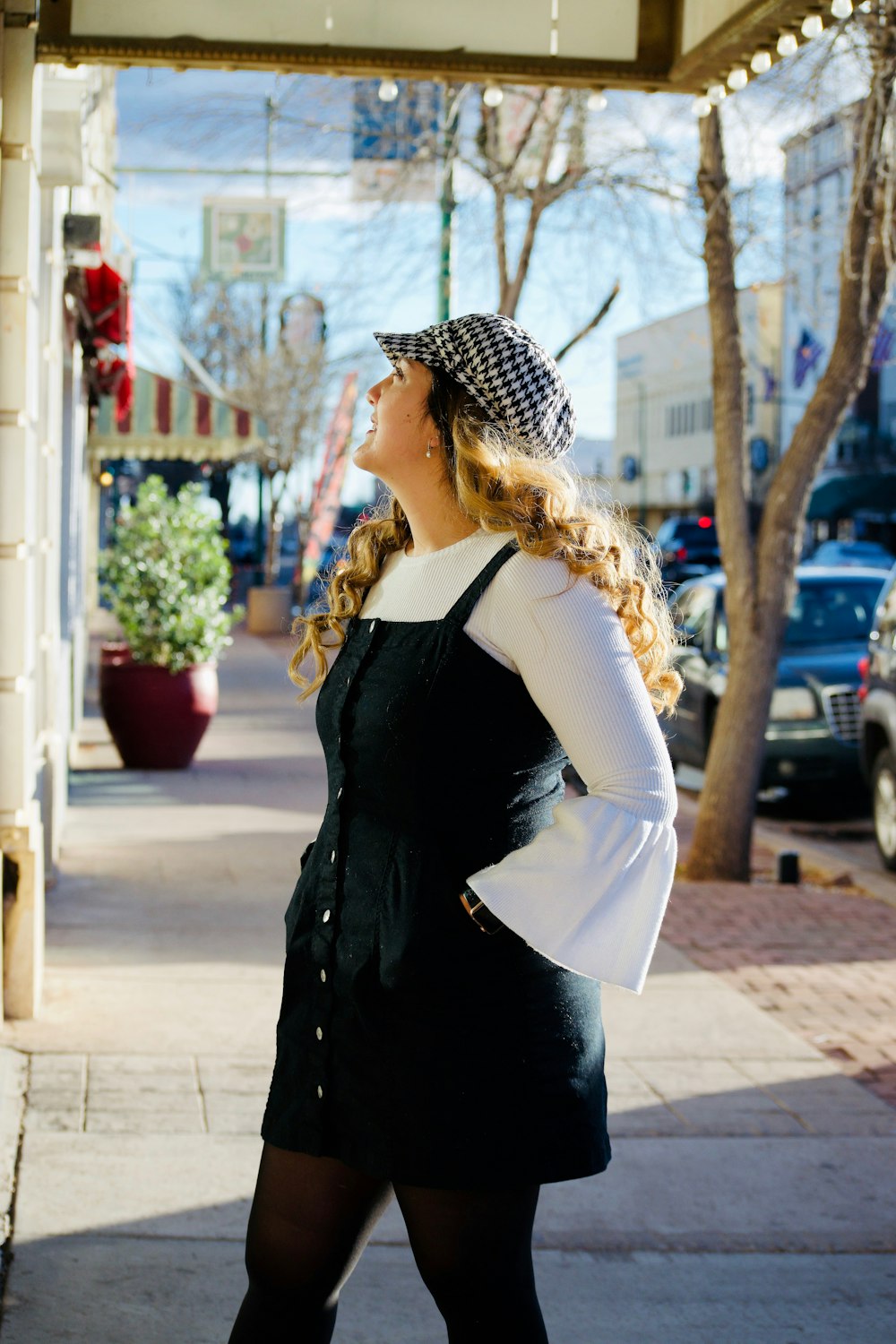 woman with hands on her pockets standing in front of building