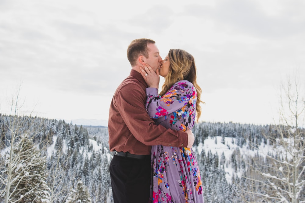 man kissing woman on grass field