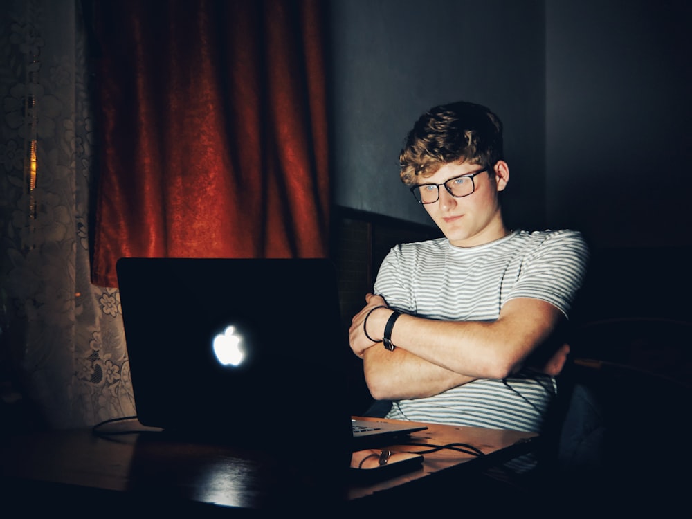 man looking at turned on MacBook