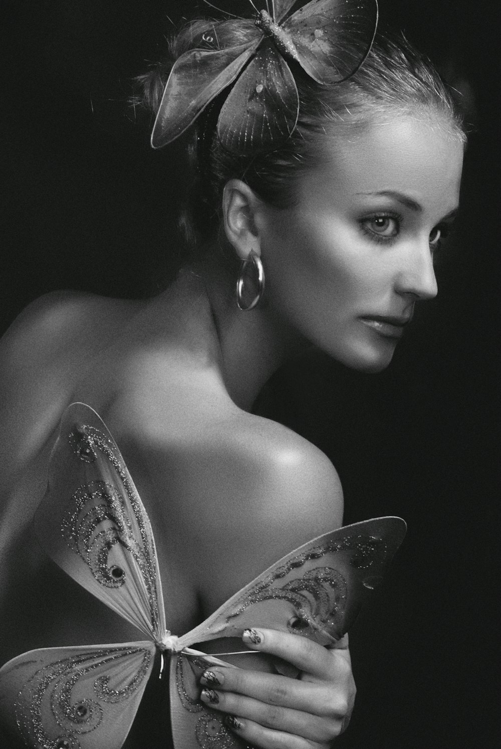 grayscale photo of woman with butterfly hair clip