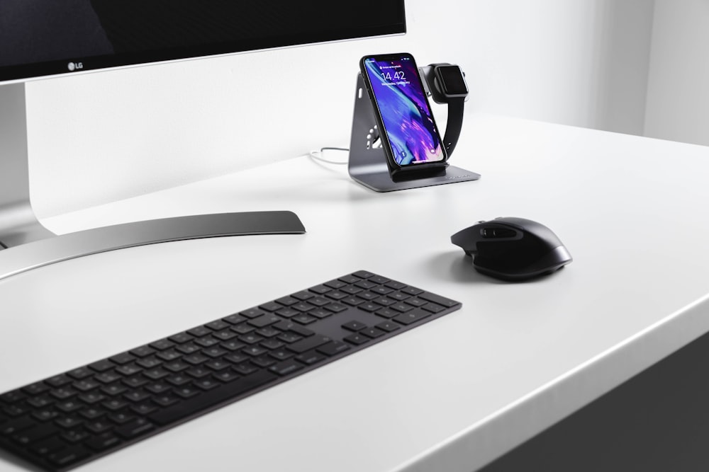 black cordless mouse and keyboard on white wooden table