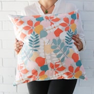 woman holding multicolored floral throw pillow