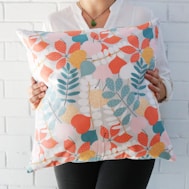 woman holding multicolored floral throw pillow