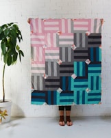 A smiling customer holding their newly finished quilt, radiating satisfaction.