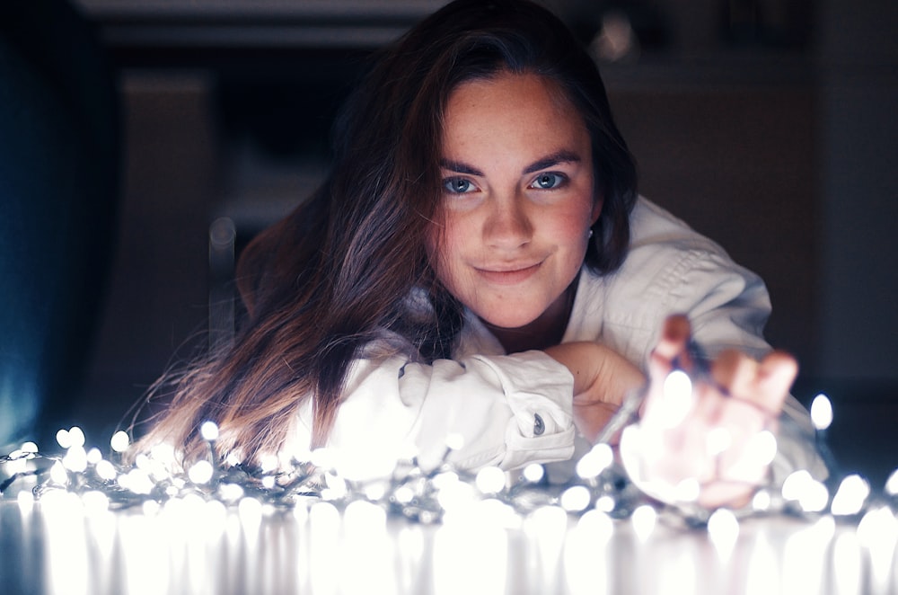 woman lying on floor with string lights