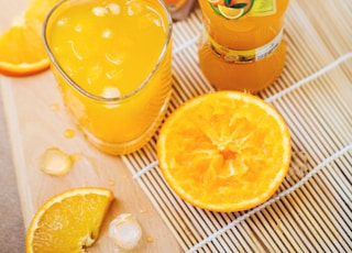 orange juice in glass beside container