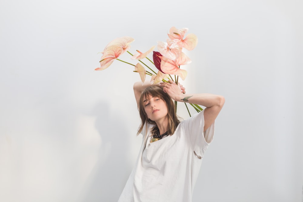 woman in white shirt carrying pink anthorium