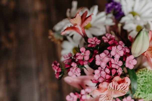 A close-up of a vibrant bouquet nestled inside a sleek, elegant flower case on a wooden table.
