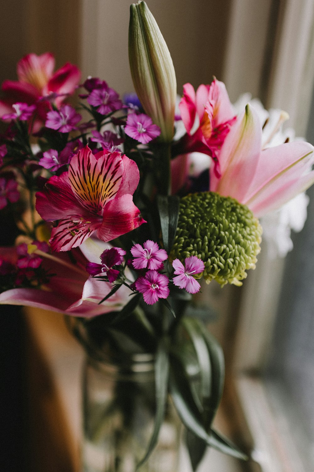 assorted flowers in clear glass vase