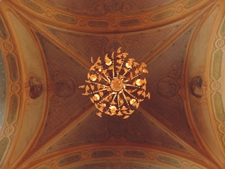 A before-and-after shot showing a high ceiling transformed by a majestic chandelier installation.