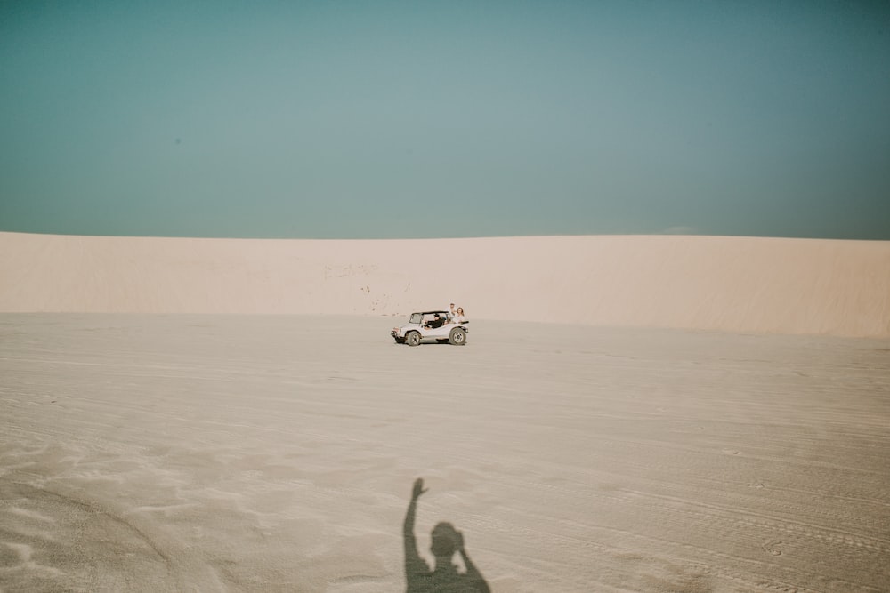 white ATV passing through dunes