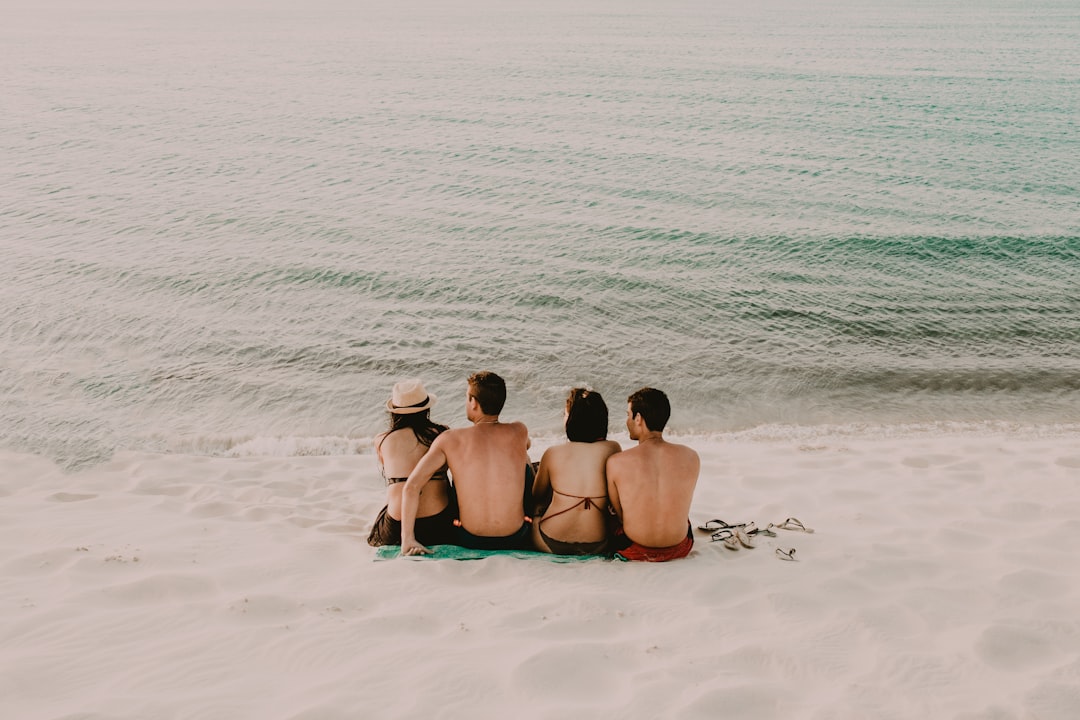 two men and women sitting on shore