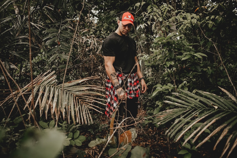 man in black crew-neck shirt surrounded by plants