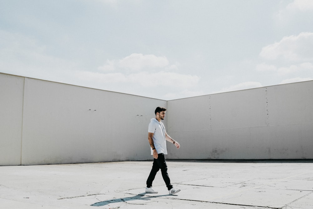 man walking on gray pavement