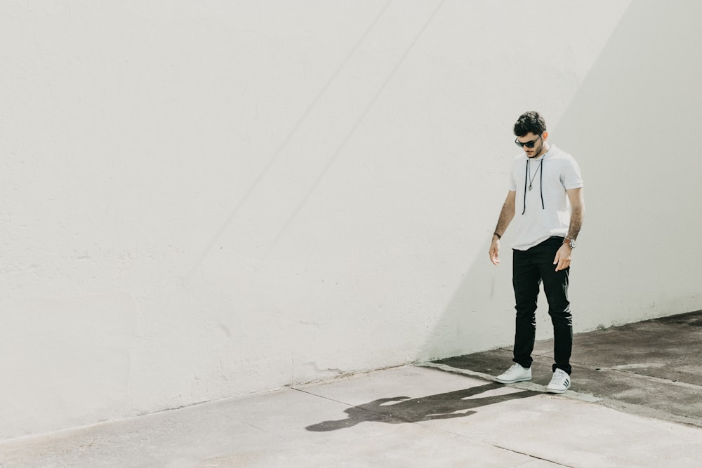 man standing beside wall