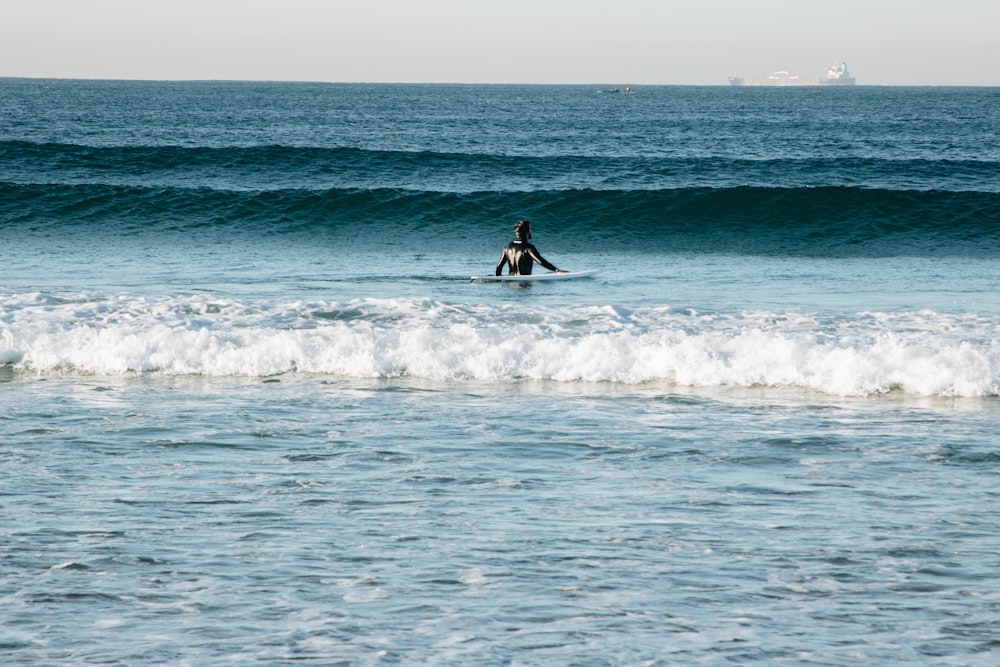 person riding on surfboard in the middle of ocean