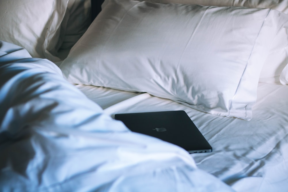 black MacBook on bed