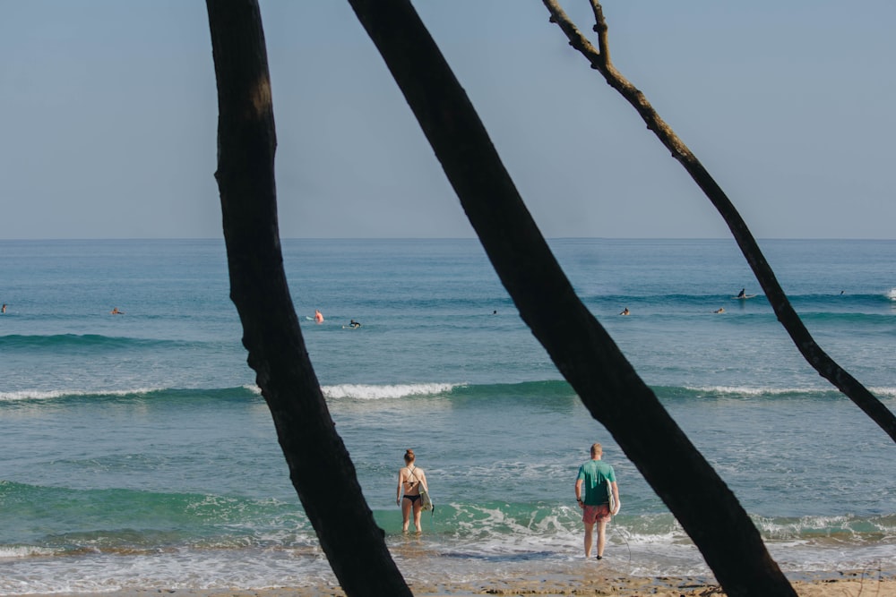 man holding surfboard near shores