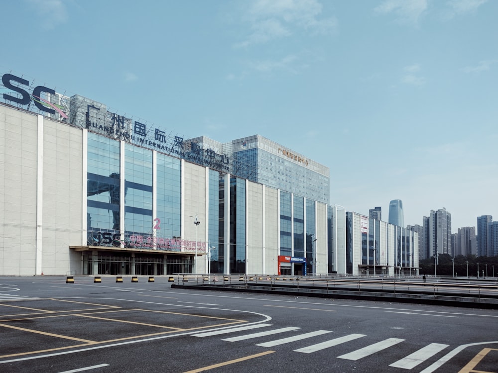 Edificio de vidrio gris y transparente bajo nubes blancas