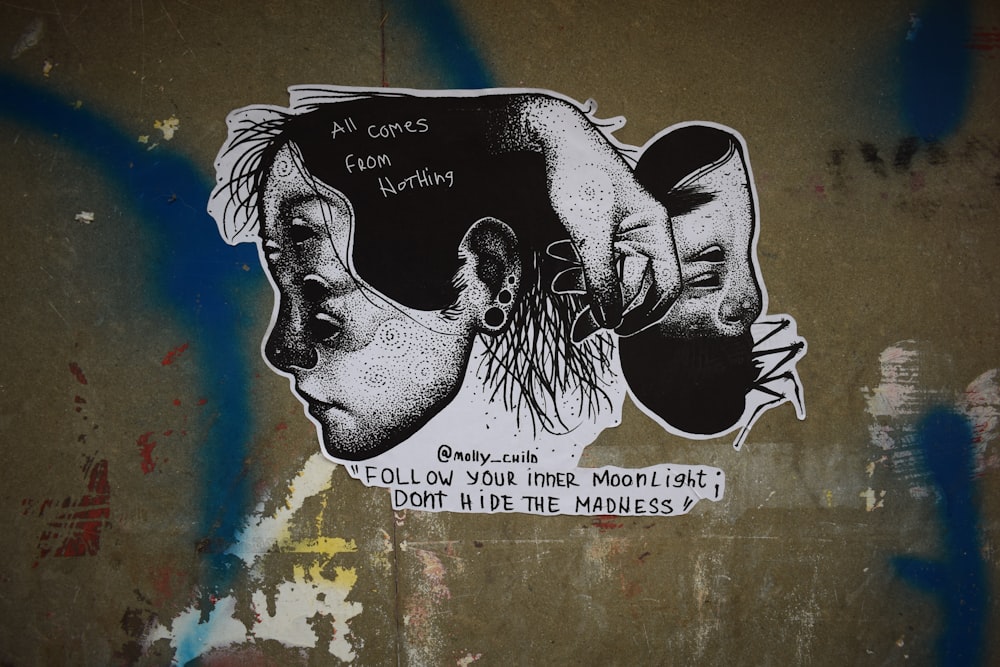 a picture of two people's faces on a wall