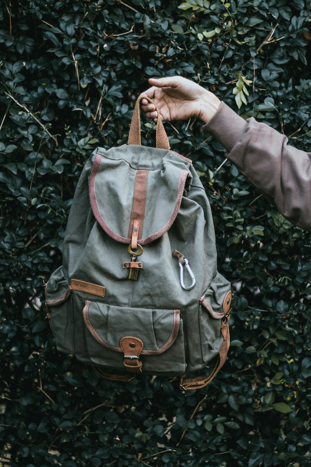 pessoa carrega mochila cinza e marrom