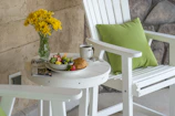 Guests enjoying a morning coffee on a wooden terrace surrounded by blooming flowers