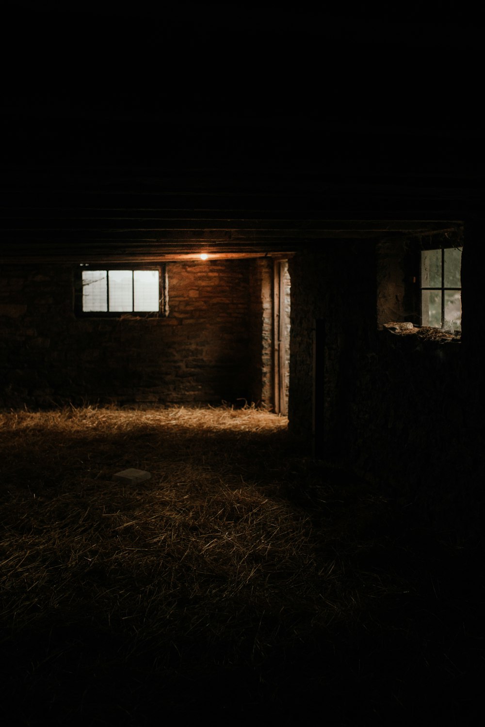um quarto escuro com uma parede de tijolos e uma janela