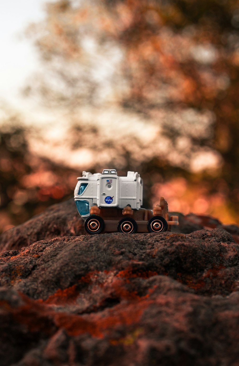Fotografía de enfoque selectivo de camión blanco y marrón en formación rocosa