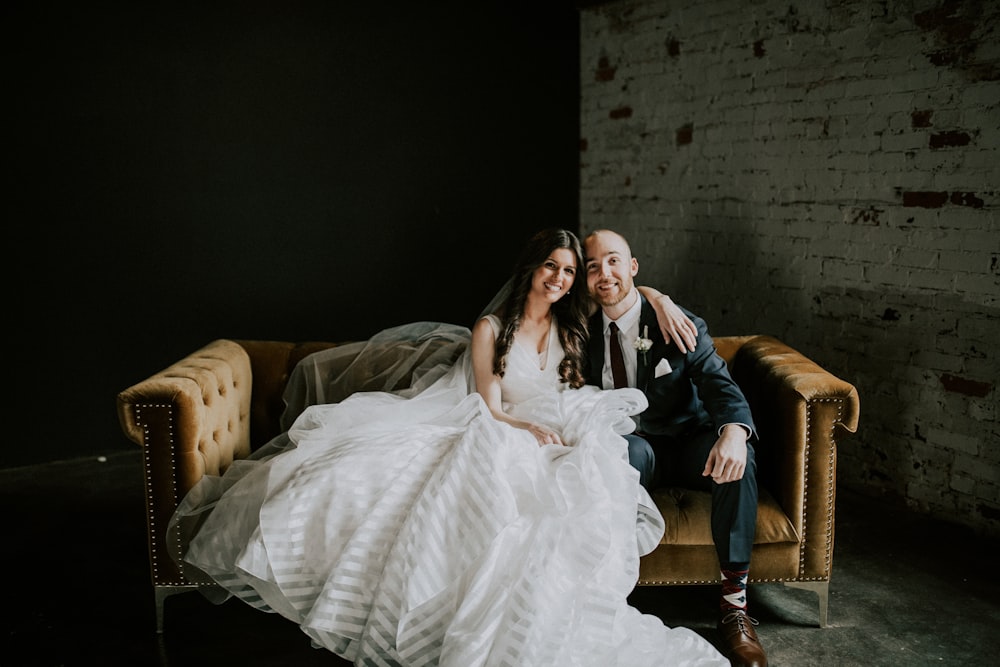 lächelnde Braut und Bräutigam sitzen auf dem Sofa