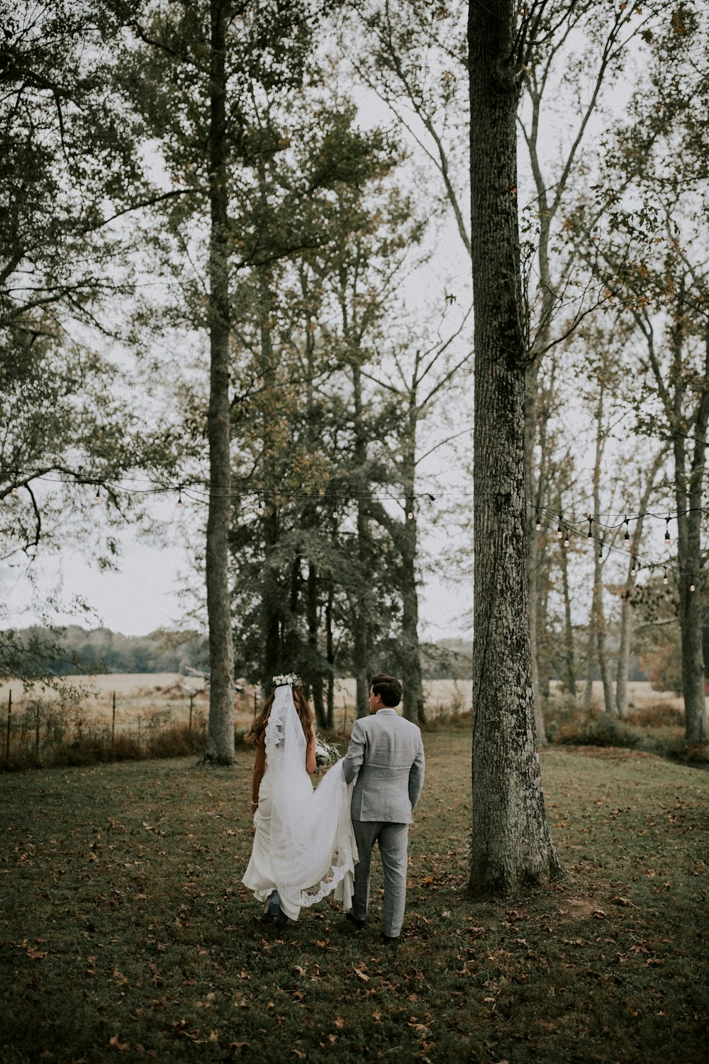 Mann und Frau, die tagsüber in der Nähe von Bäumen spazieren gehen