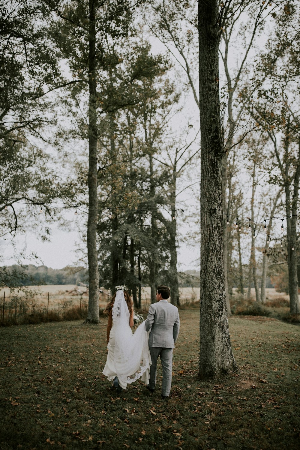 man and woman walking near trees during daytime