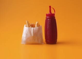 fried fries in white pack beside red squeeze bottle